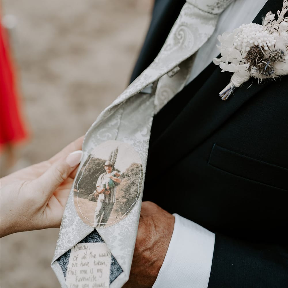 Father of the bride with white paisley tie with stitched photo and personalised message from the bride with white buttonhole 