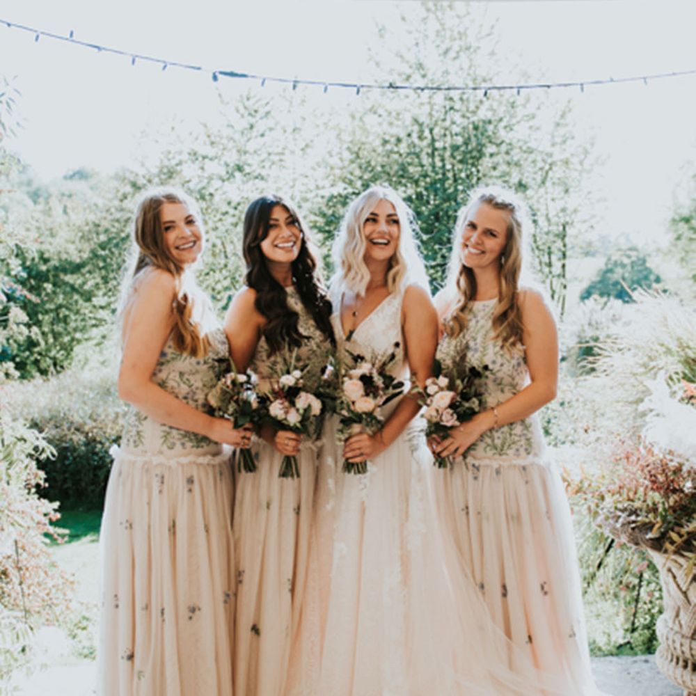 Bride in lace wedding dress with bridal party in sleeveless tulle embellished bridesmaid dresses 
