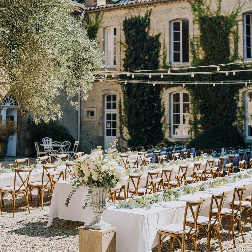 al fresco wedding reception at Château de Malliac with white flowers and festoon lights 