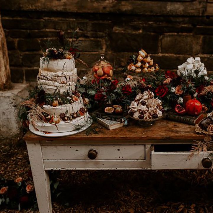 Boho wedding with macarons, pavlova, marshmallows and fruits on the wedding dessert table 