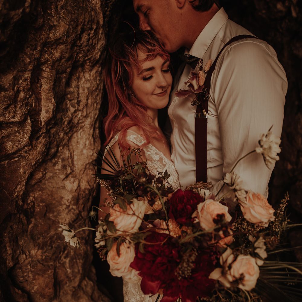 Groom kissing his brides head