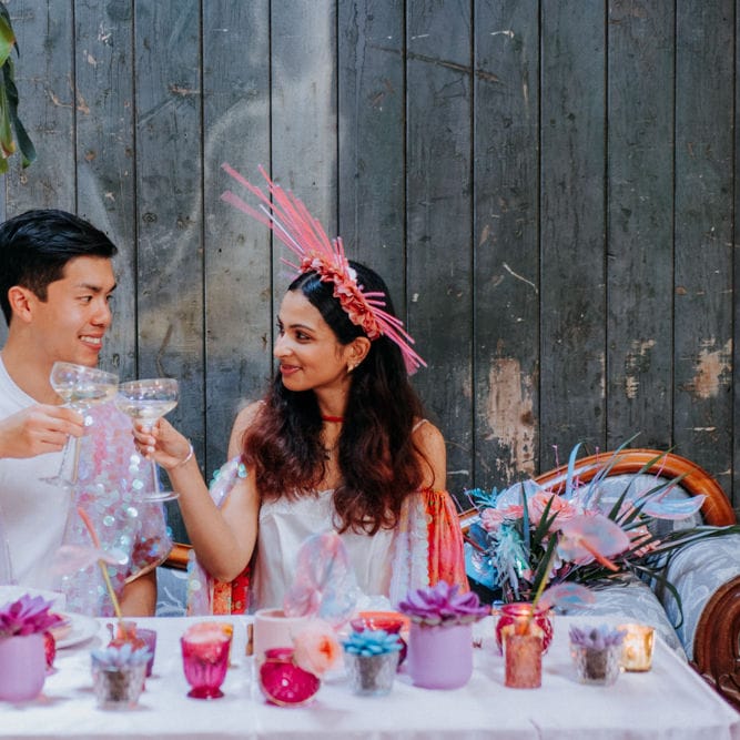 Bride and groom sipping champagne at sweetheart table 