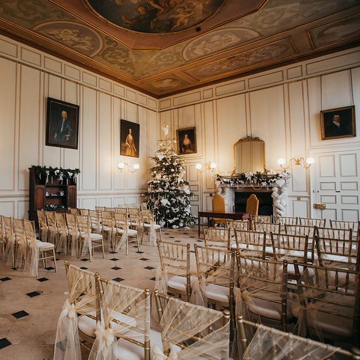 Gosfield Hall wedding venue complete with Christmas decor and chairs finished with gold chiffon bows