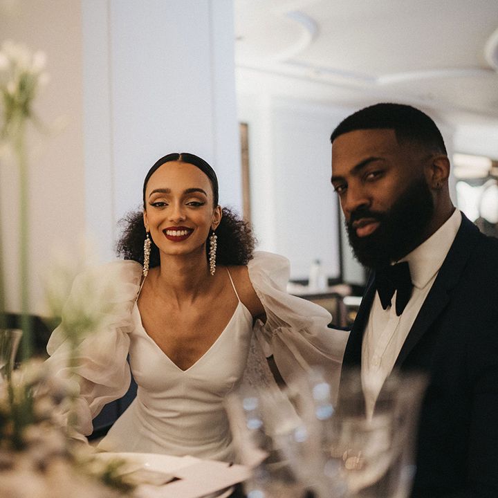 Stylish Black bride and groom at Mayfair Townhouse wedding venue in a tuxedo and camisole wedding dress with detachable sleeves 