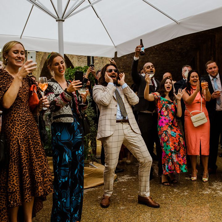 Wedding guests applaud outside for summer wedding in the city 