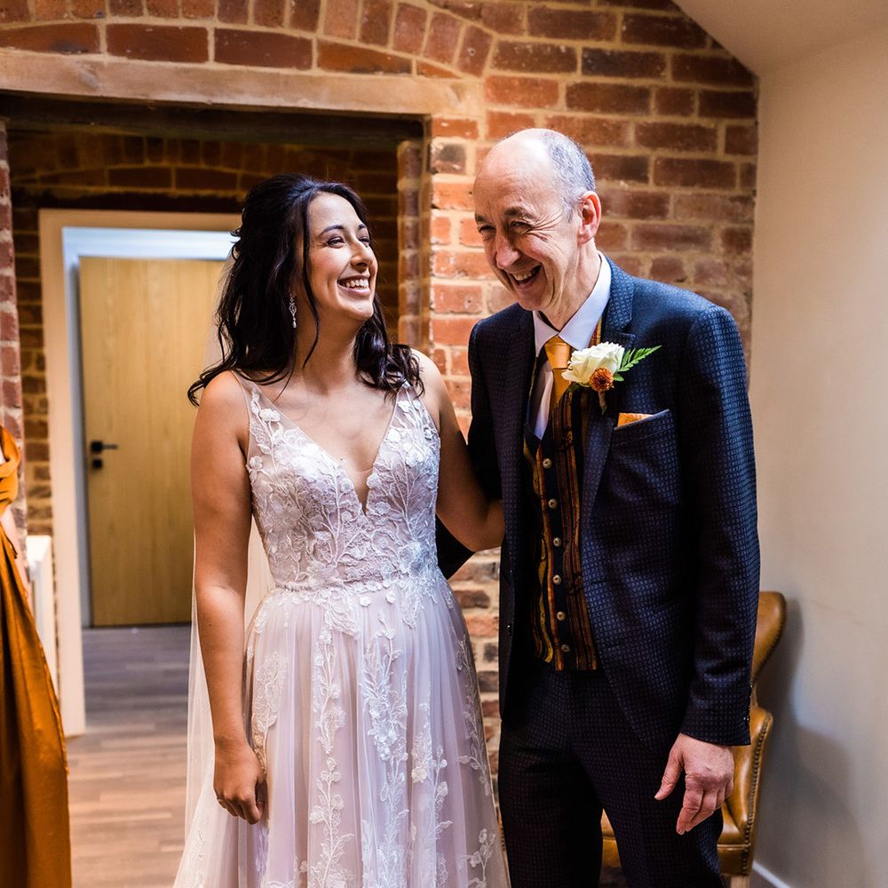Bride in v neck illusion lace floral tulle wedding dress with father in patterned blue suit with yellow tie and fun yellow waistcoat