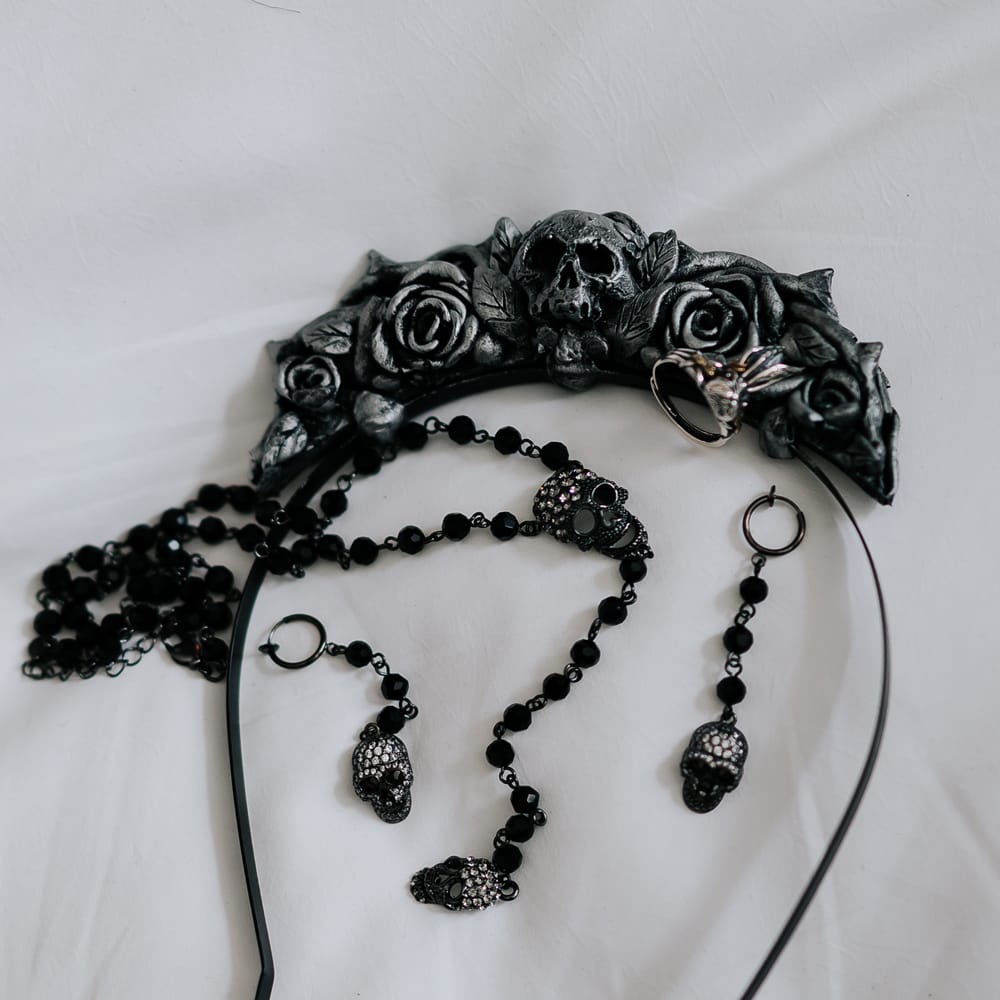 Skull bridal crown beside black bridal accessories with skull detailing for gothic wedding style
