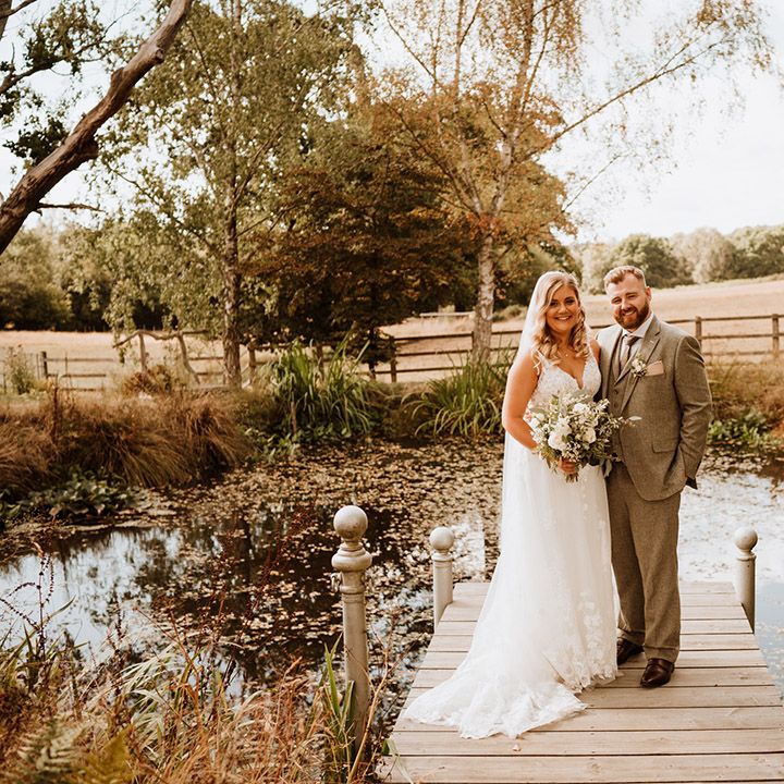 The happy couple pose together outdoors at The Oak Barn for their couple portraits 