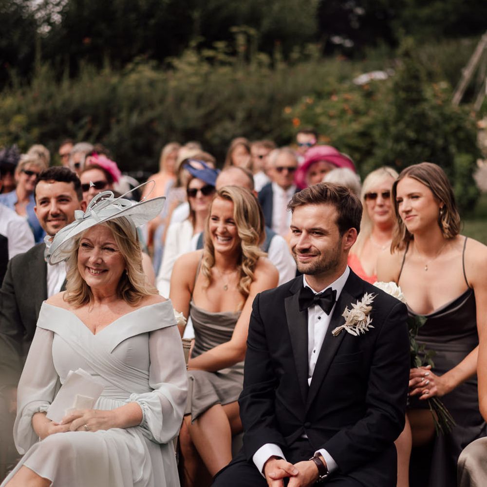Black tie boho wedding with wedding guests in dark tones surrounded by dried flowers 