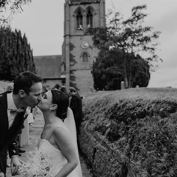 Bride and from she a kiss after their confetti exit from the church ceremony 