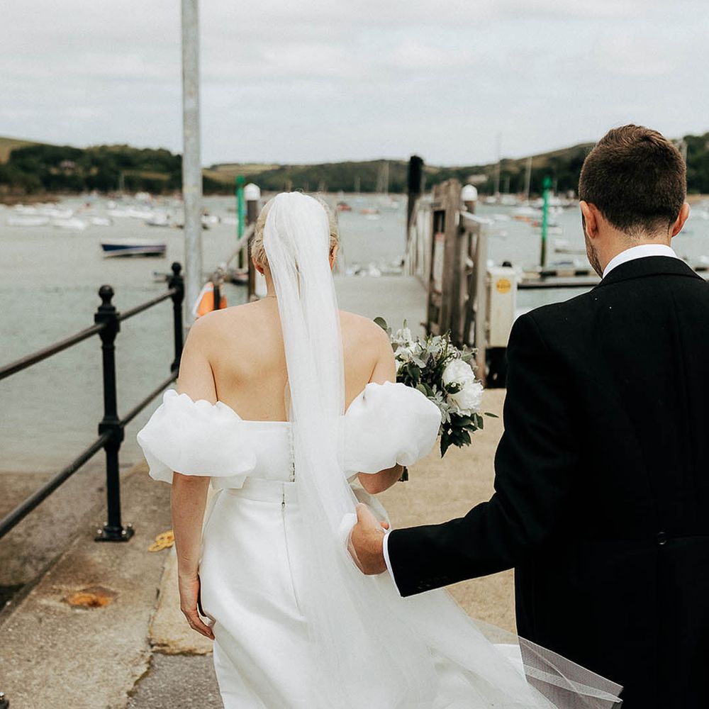 Bride wears floor length veil in her blonde hair worn in a bun