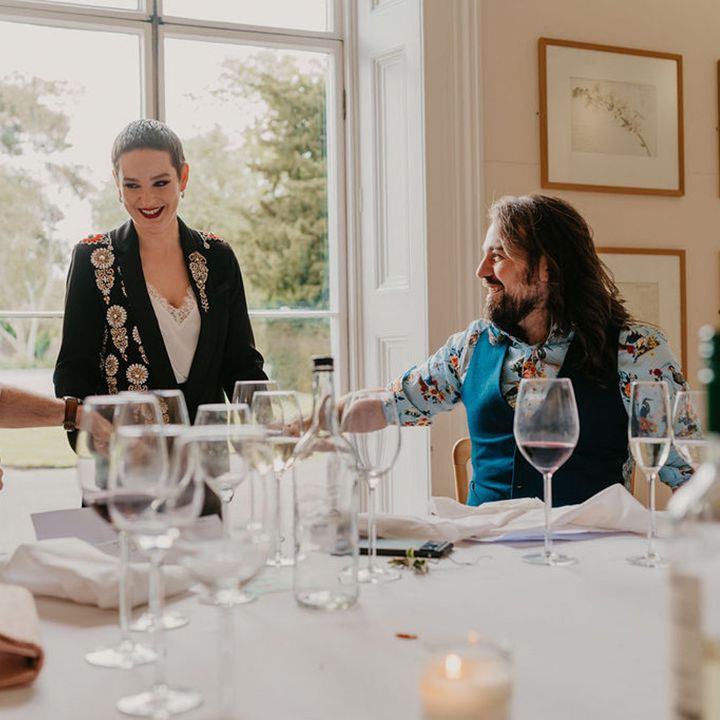 Wedding guests and grooms listen during intimate speeches 