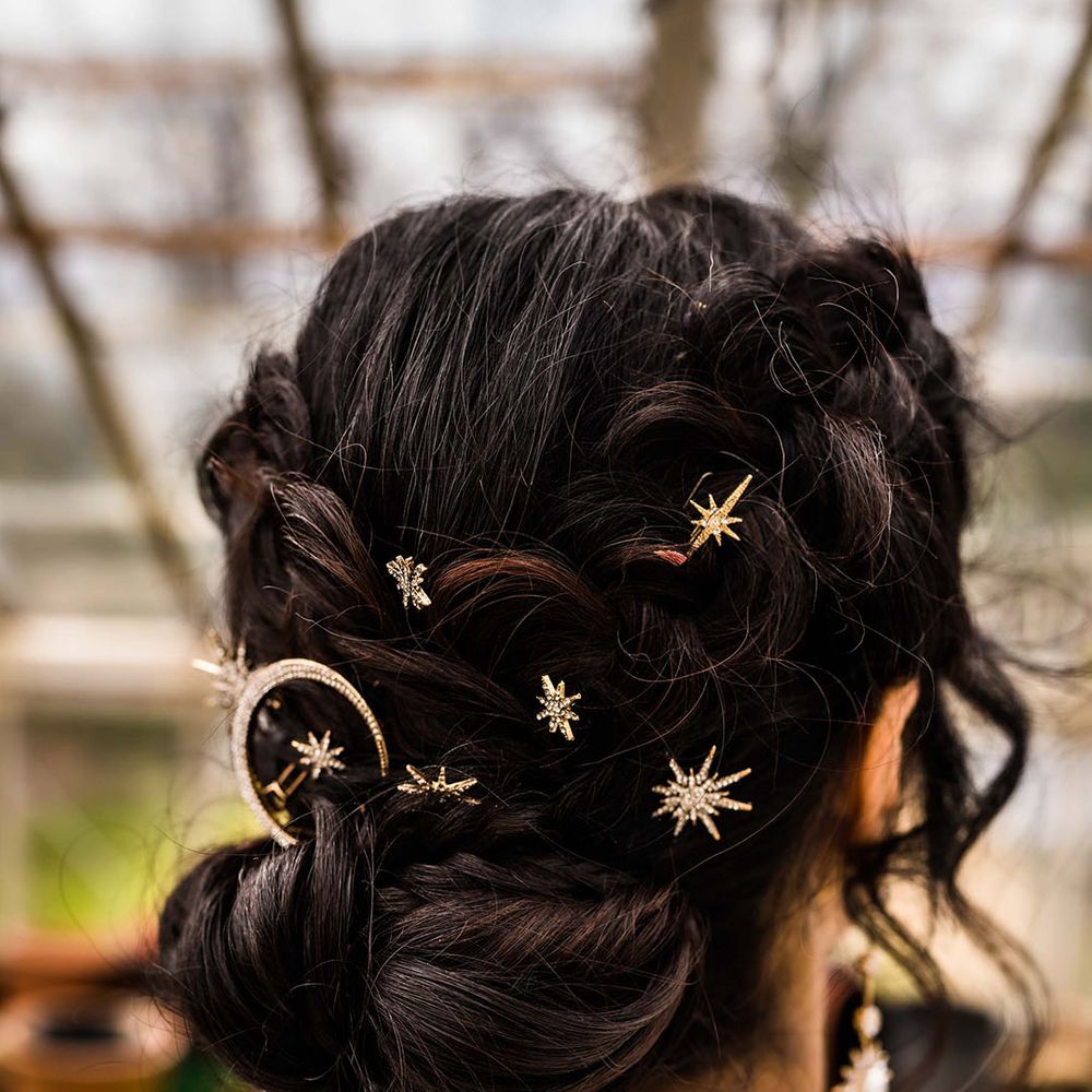 Bride wears gold embellished celestial styled hair accessories 