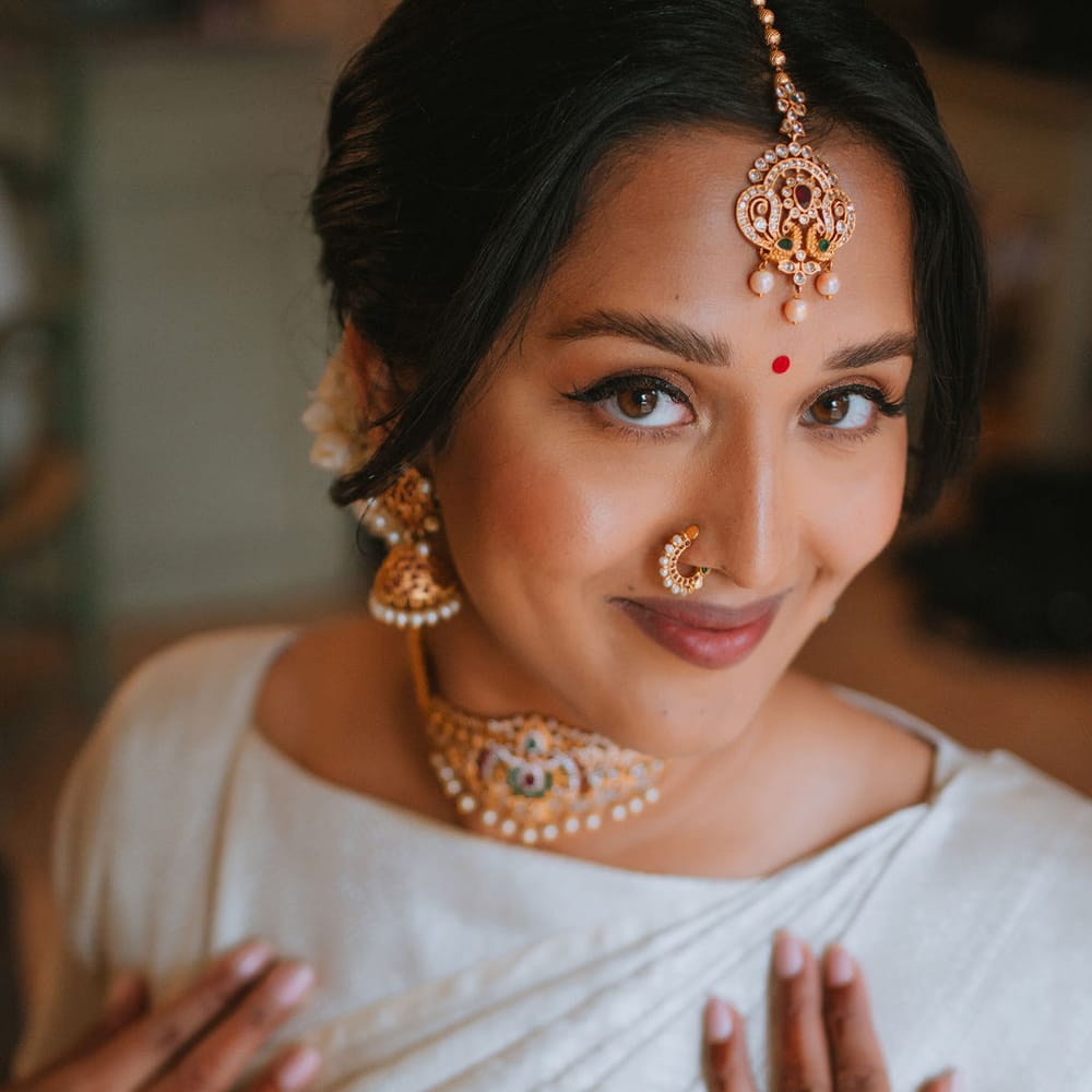 South Asian bridal makeup in a cream Lehenga and Indian gold jewellery 