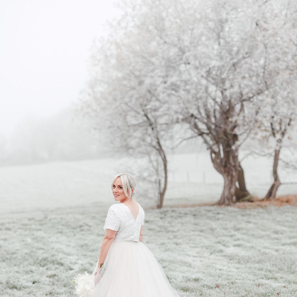Frosty wedding day with the bride in tulle bridal skirt and beaded top with short sleeves 