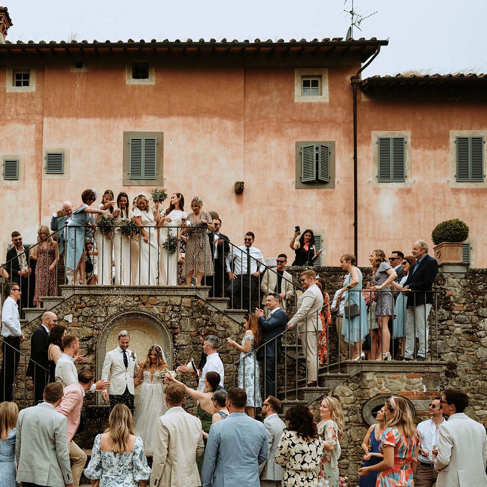 Group photo with bride, groom and wedding guests and confetti shot at Italian villa wedding in Tuscany