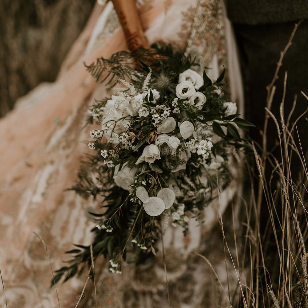 Bride holding classic and traditonal all white wedding bouquet 