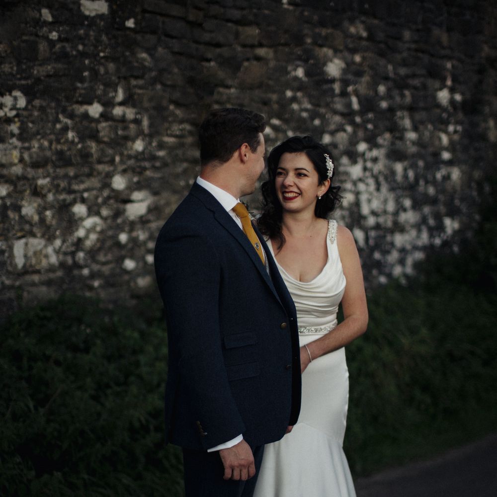 Bride & groom look at each other during post wedding photoshoot