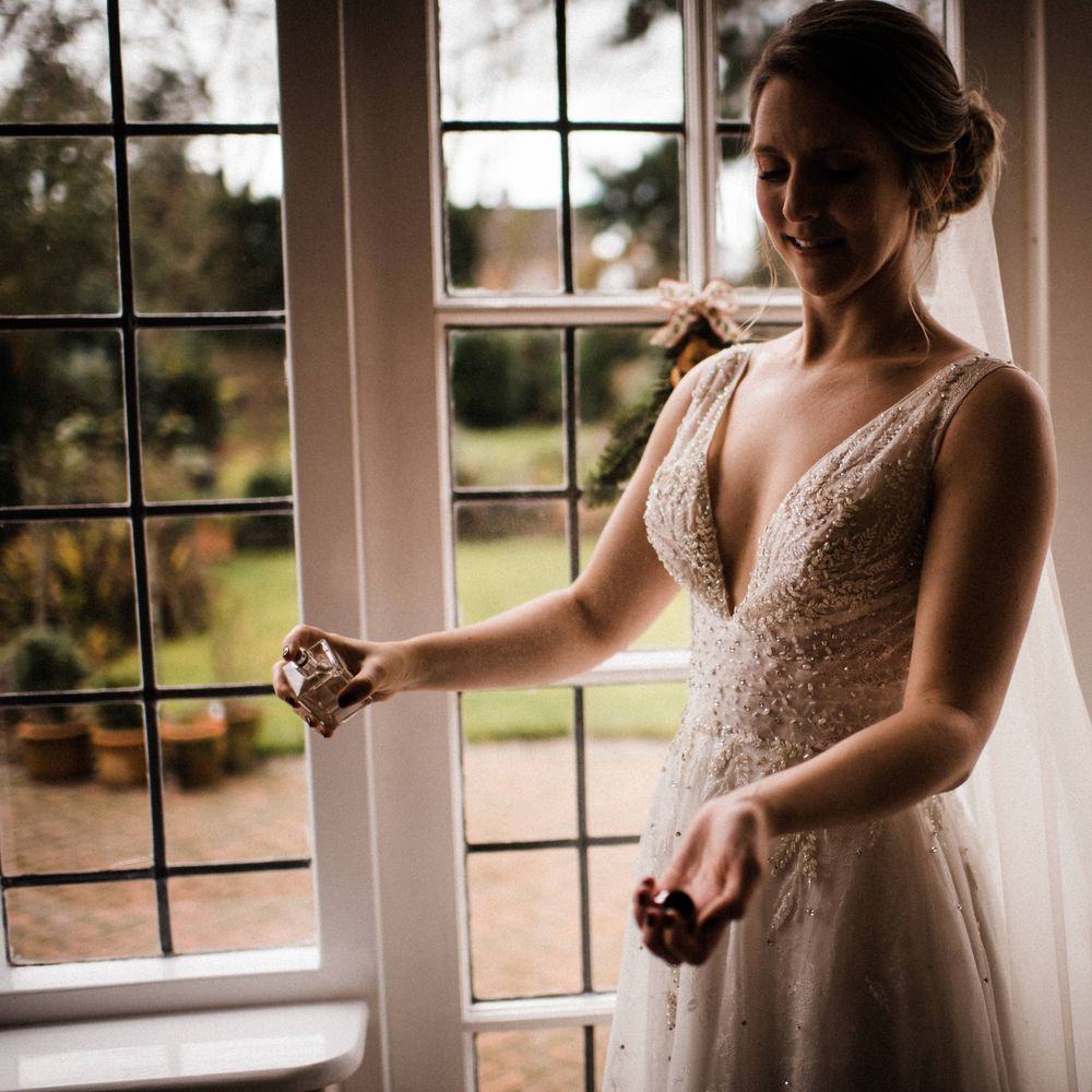 Bride sprays perfume on the morning of her wedding
