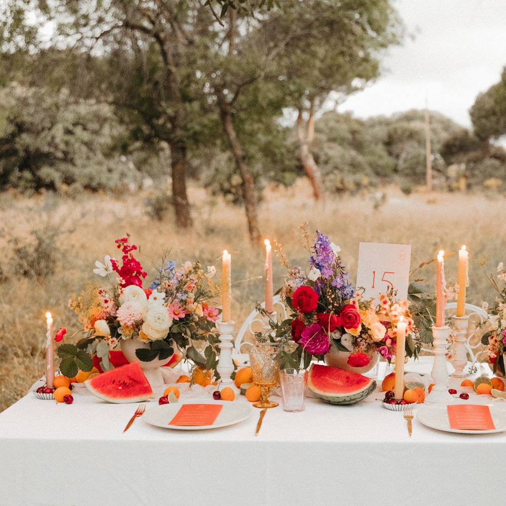 Bright & bold tablescape complete with floral bouquets, candles and gold cutlery