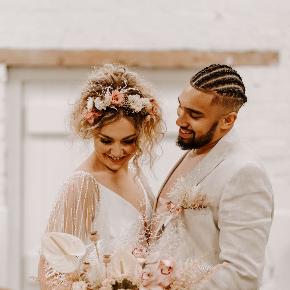 Bride and groom with pink and white florals for a tropical wedding theme