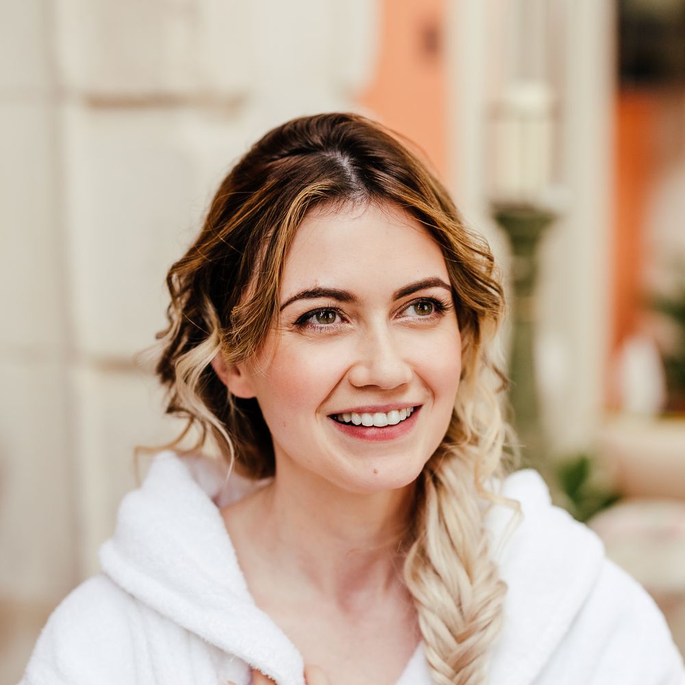 Blonde bride has her makeup done on the morning of her wedding