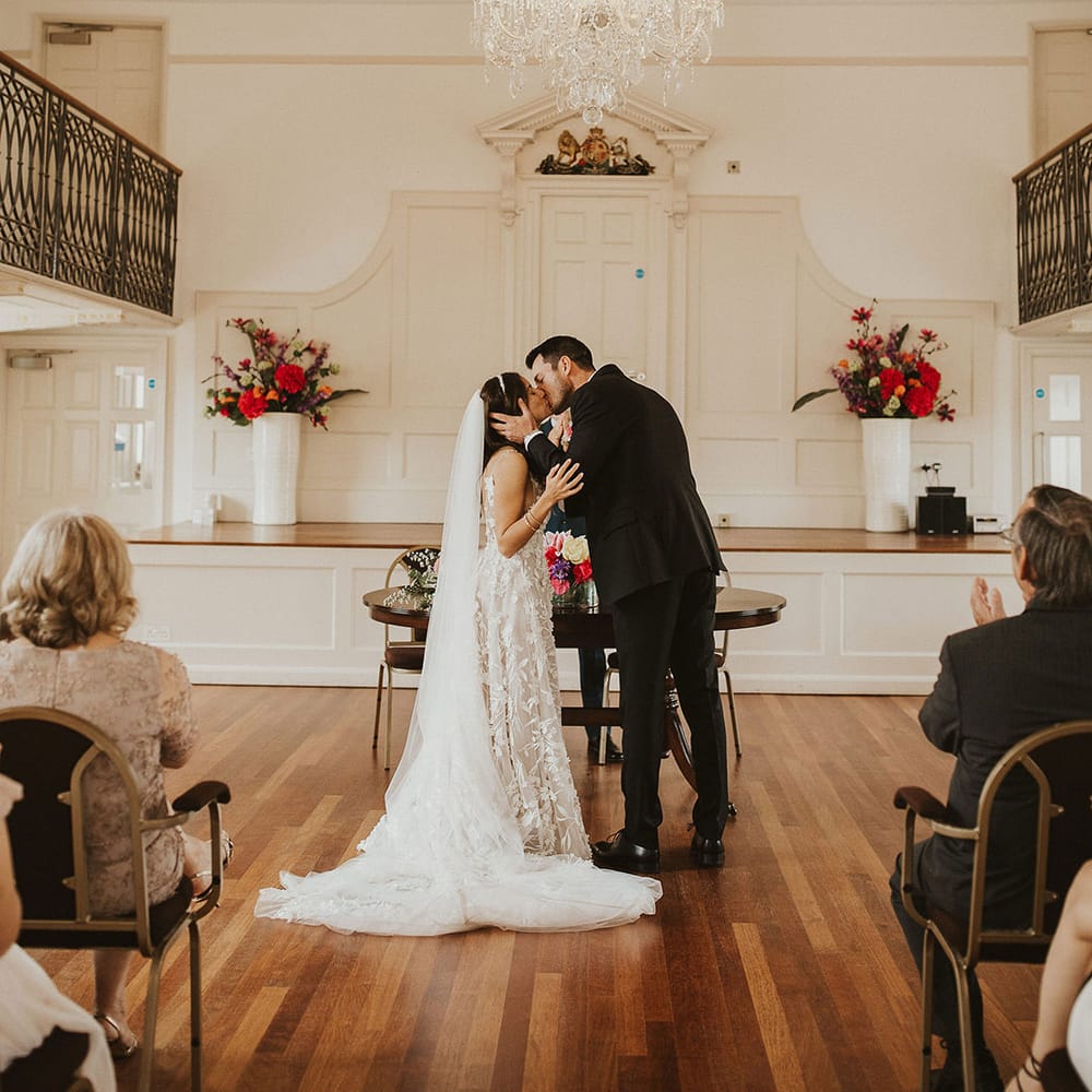 Bride & groom kiss on their wedding day during wedding ceremony