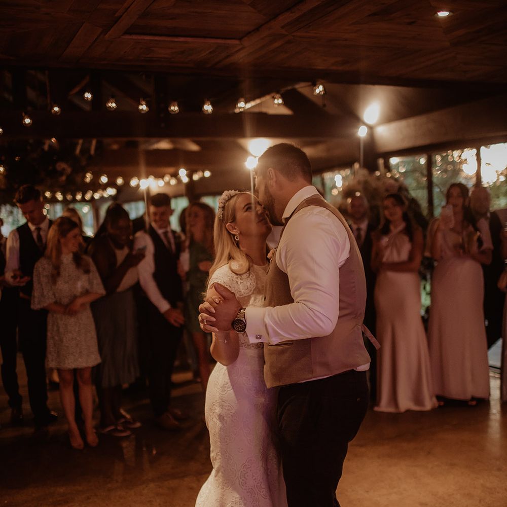First dance at Dewsall Court with bride in a lace cap sleeve wedding dress and groom in a waistcoat