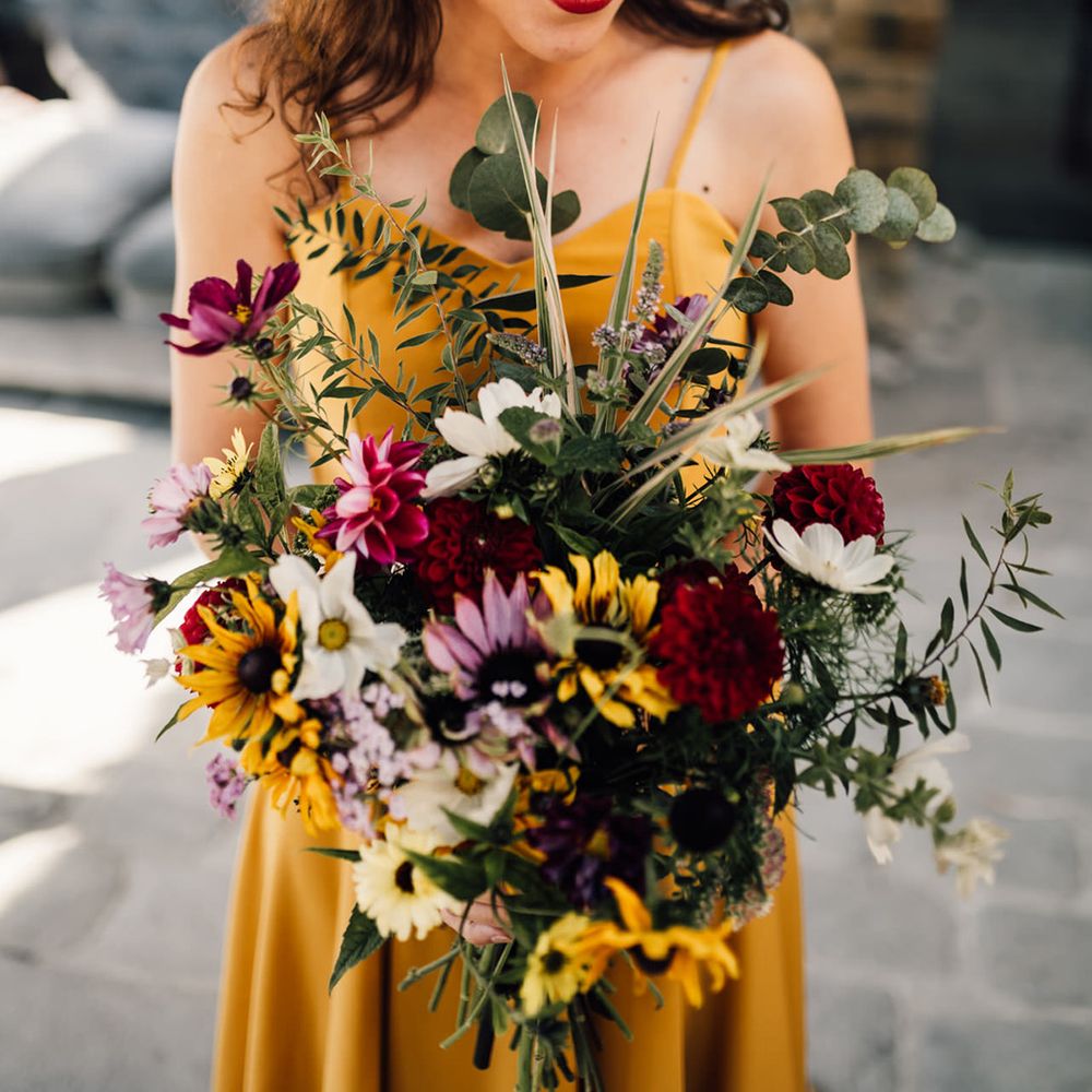 Bride holds colourful floral bouquet