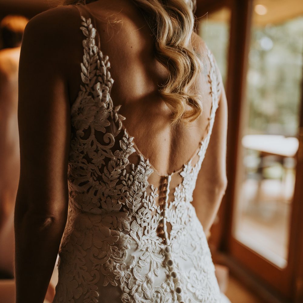 Bride in low back lace wedding dress with button back detailing before Lake District wedding
