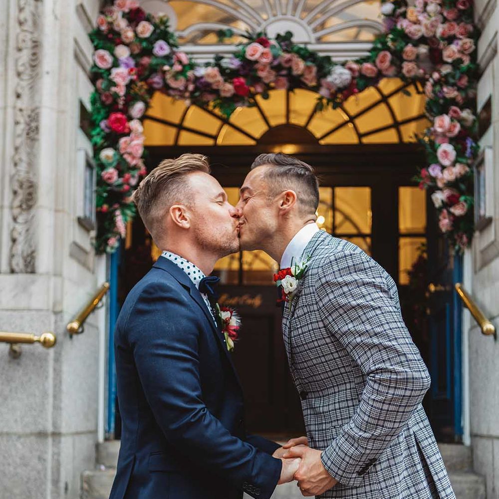 Grooms kiss on the steps of Chelsea Old Town Hall on their wedding day