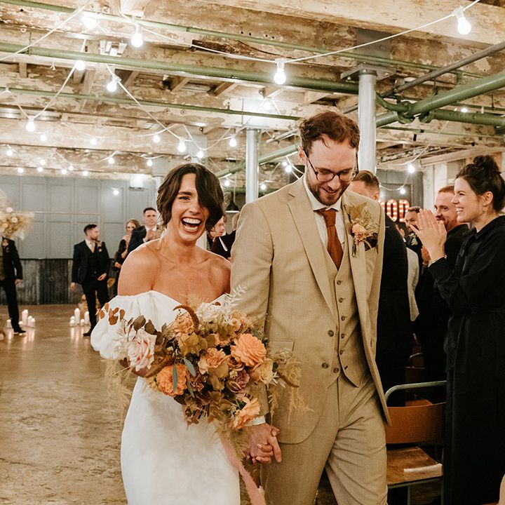 Bride and groom exit their wedding ceremony at industrial venue 