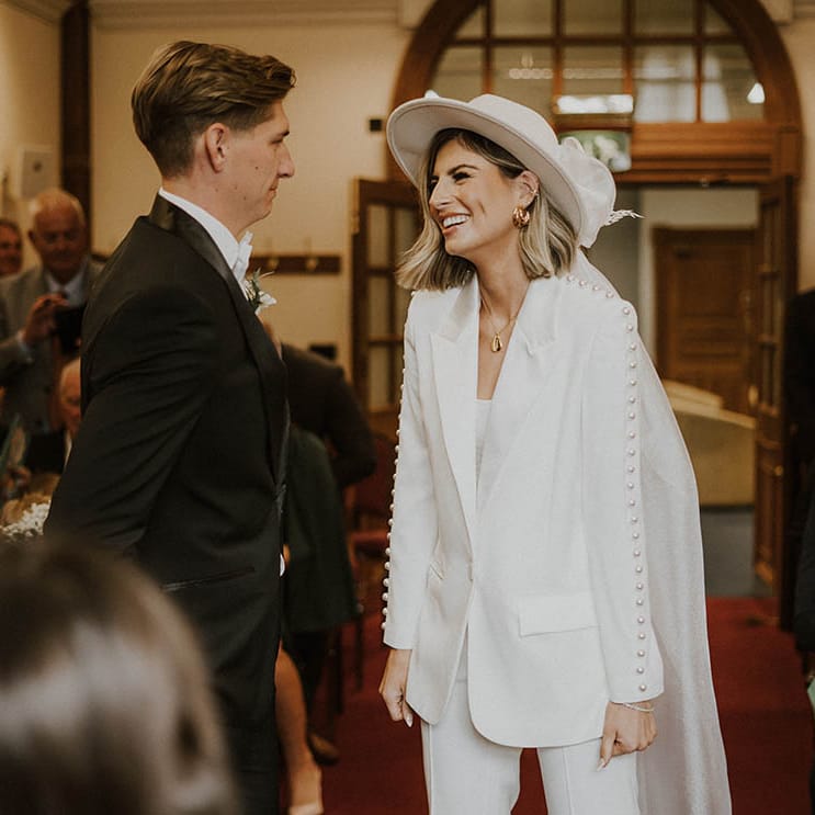 Bride and groom smile during wedding ceremony at town hall 