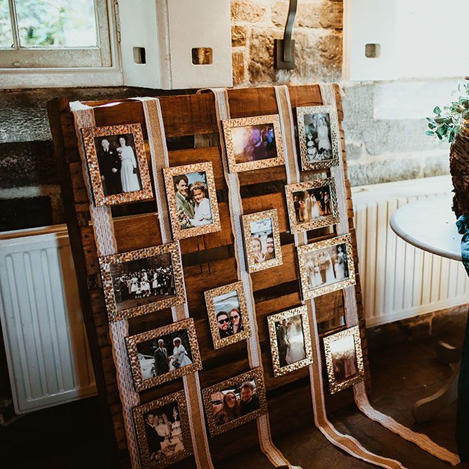DIY pallet photo wall beside tree trunk cake stand for beach wedding in Cornwall 