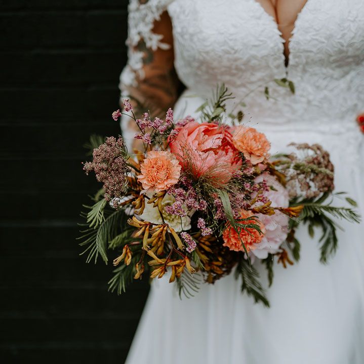 Brightly coloured floral bridal bouquet complete with green foliage 