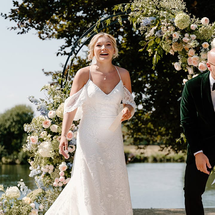 Bride & groom laugh during wedding ceremony outdoors at the Bisham Abbey