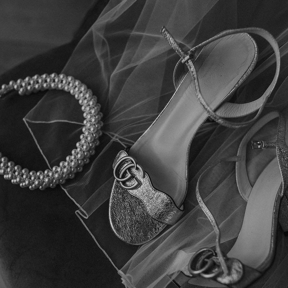 Gold strappy heels and pearl headband on top of wedding veil at Hackney Studios