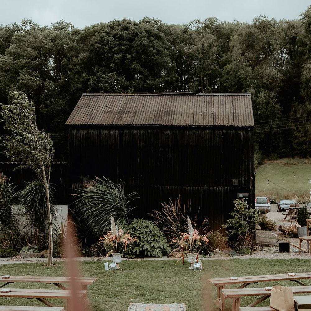 Rhyse Farm wedding wedding venue with dried pampas grass decor with Persian rugs lining the aisle for the outdoor wedding 