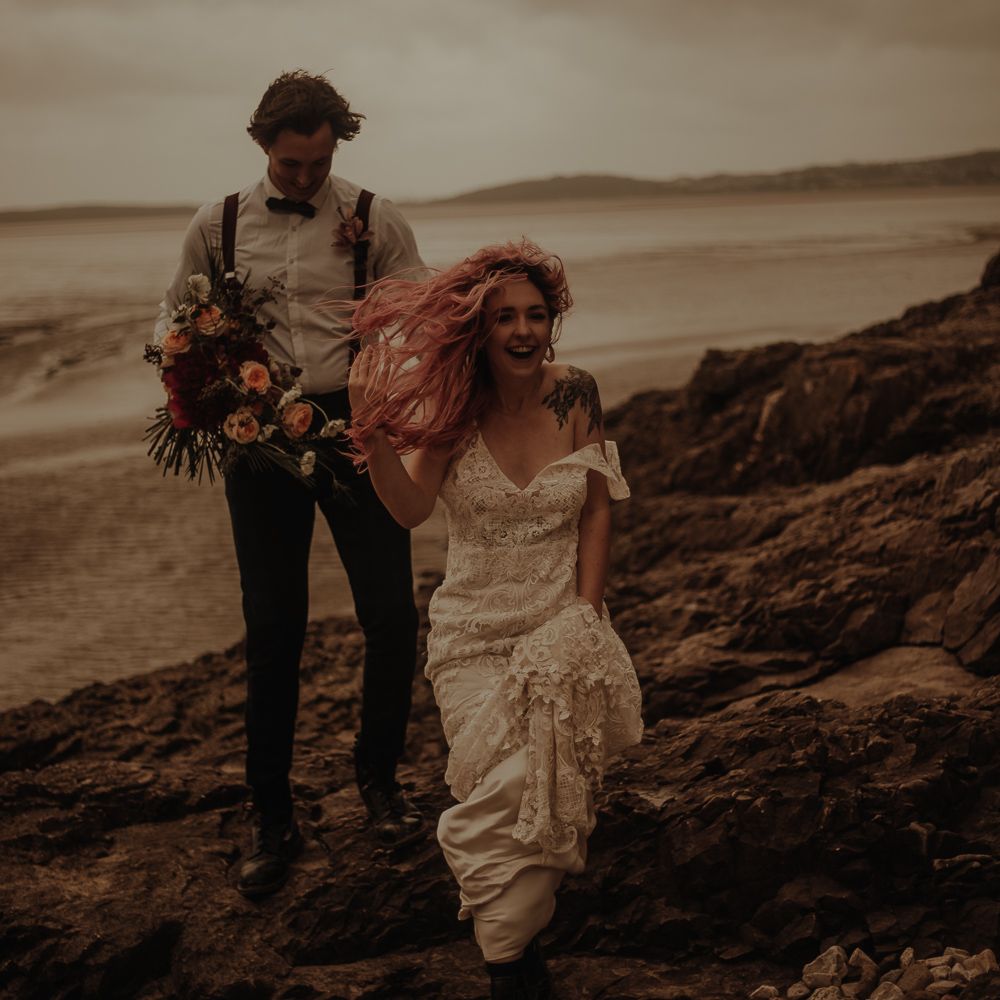 Bride with pink hair blowing in the wind at beach elopement