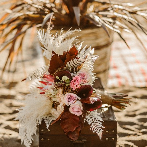 Wedding bouquet with pink flowers, leaves and dried grass