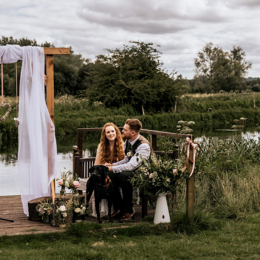 Bride & groom during their wedding ceremony surrounded by floral bouquets 