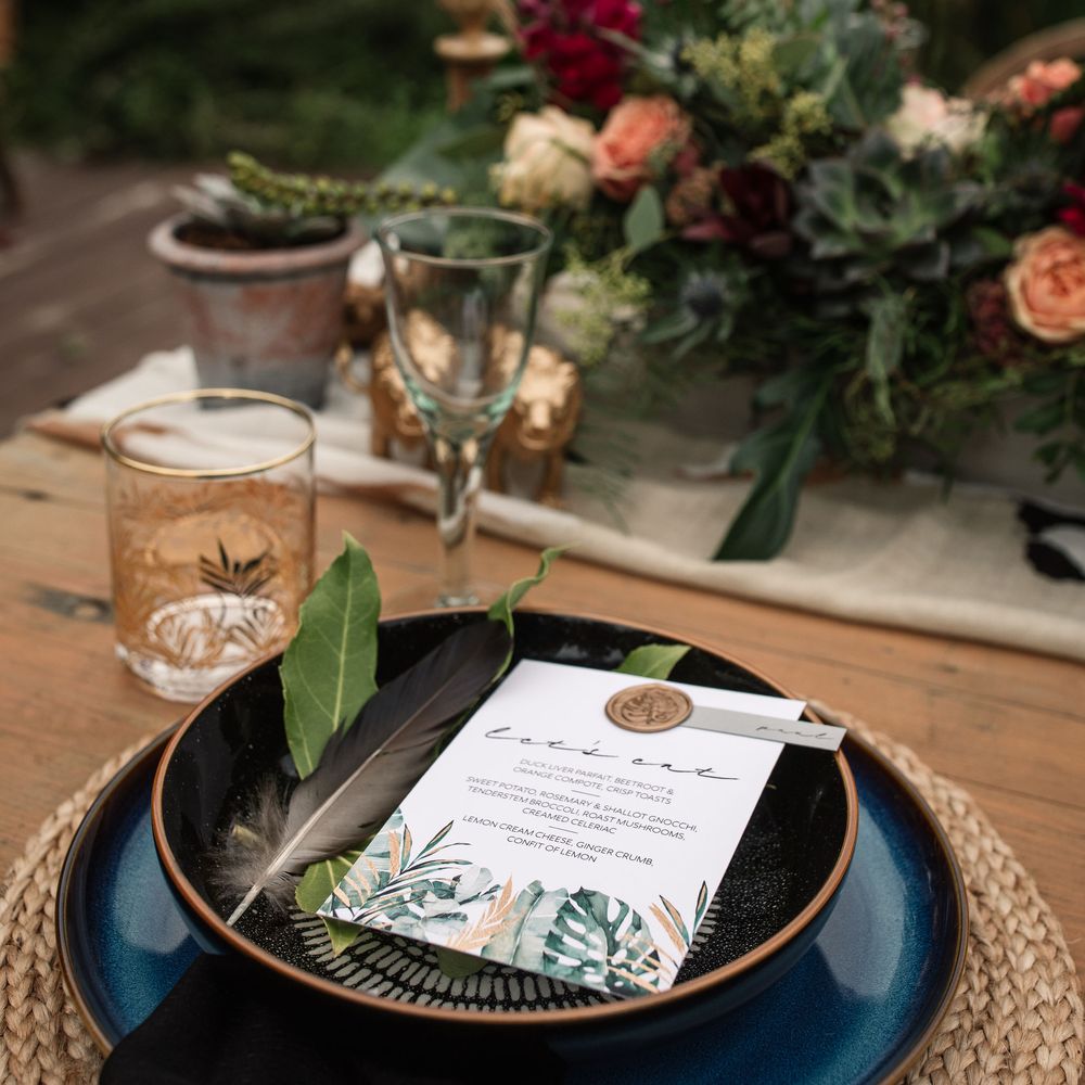 Black plates with floral decor and wedding stationery