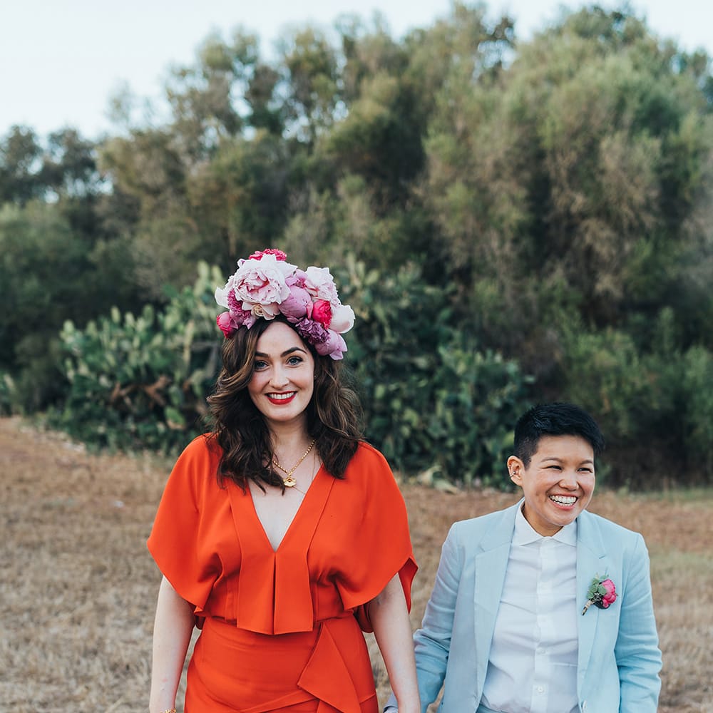 Brides stand together and hold hands for post wedding photoshoot in Menorca