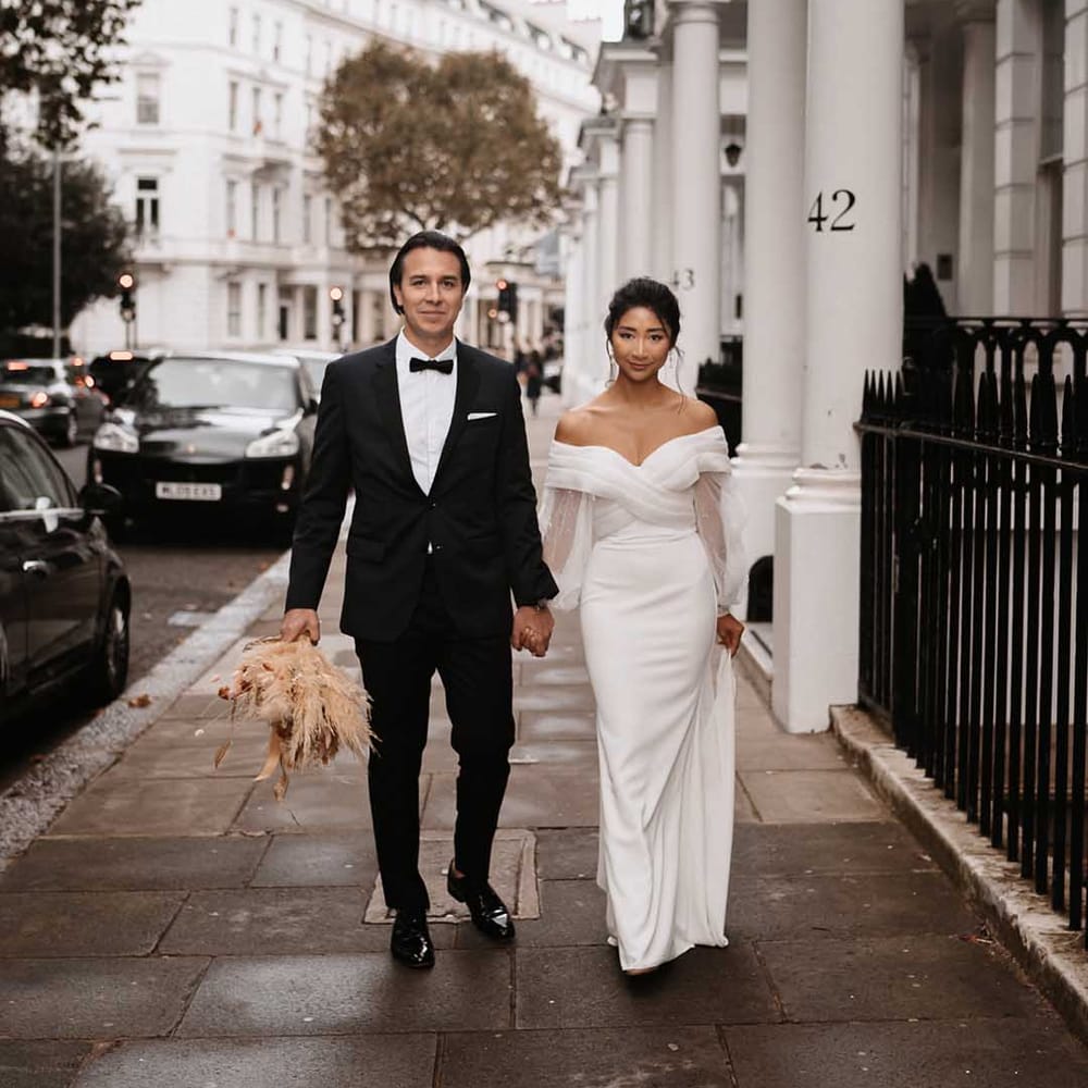 Groom in black tux with bow tie and white shirt and bride in elegant cross over wedding dress in Chelsea 