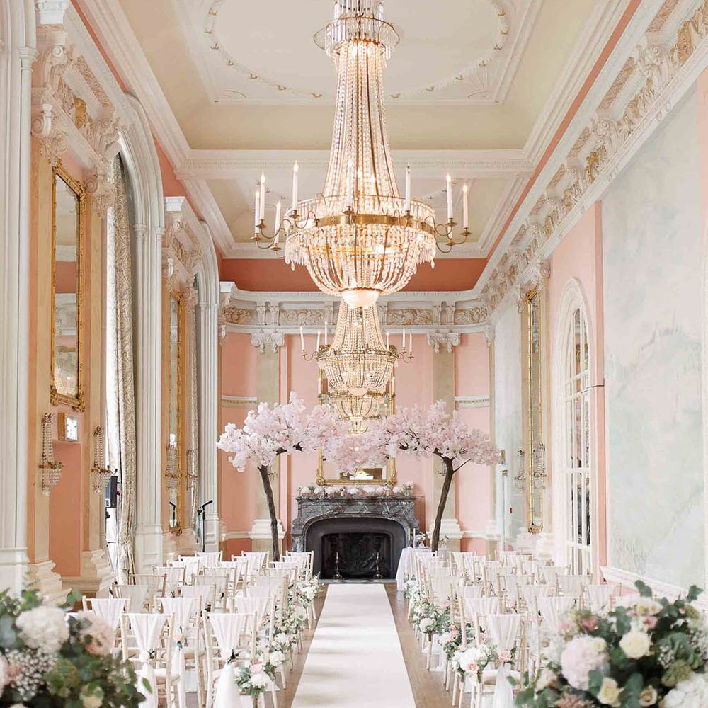 Danesfield House complete with blossom tree archway, grand chandelier and white seats with white bows 