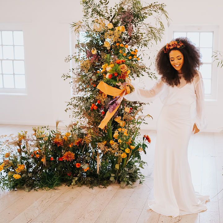 Core Clapton Events Minimalist wedding venue with column flowers and Black bride in a satin slip wedding dress with sheer long sleeve top