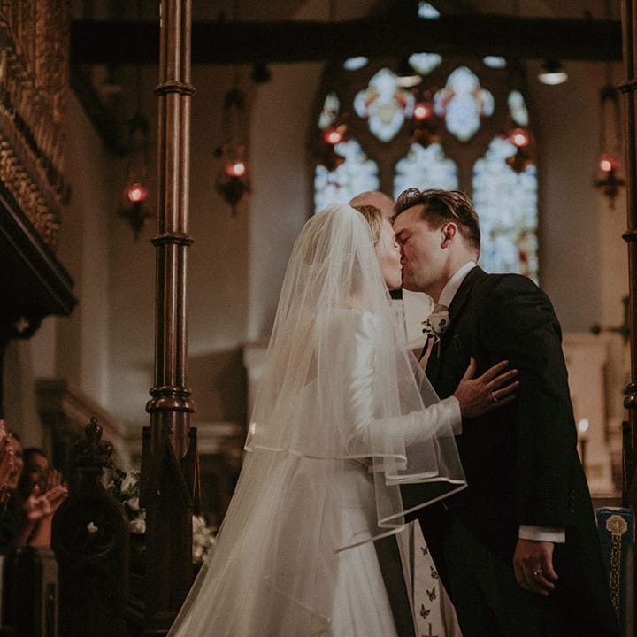 Bride and groom at the alter, bride in long white wedding dress and veil at Hedsor House wedding 