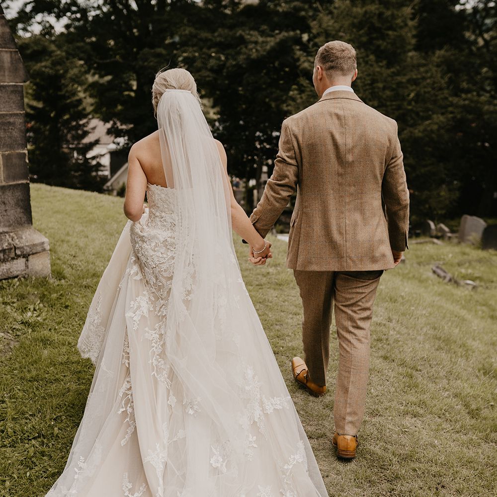 Bride and groom walk hand in hand together around their wedding venue