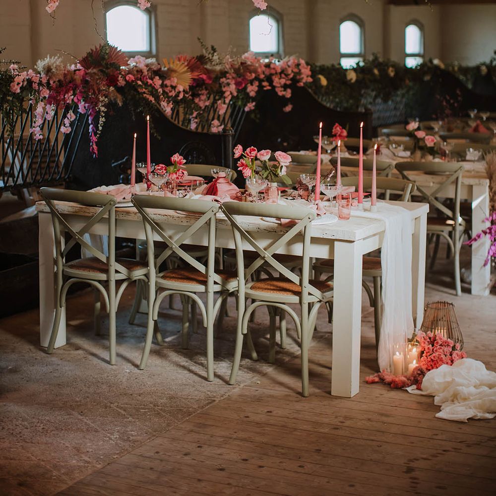 Prestwold Hall Barn wedding reception with pink taper candles, pink flowers, cherry blossom installation and wooden furniture 