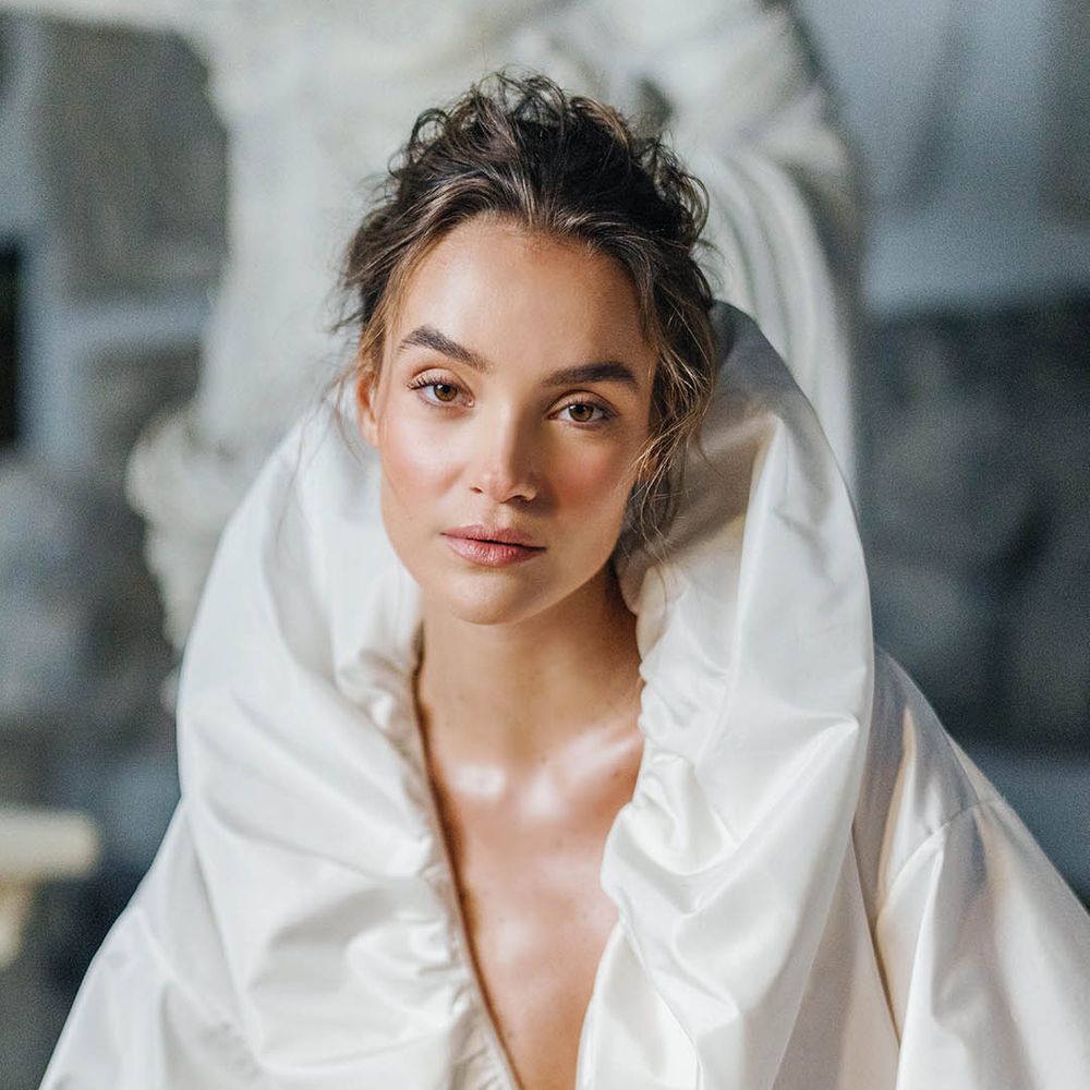 Bride with glowy natural makeup and messy updo with puff wedding dress